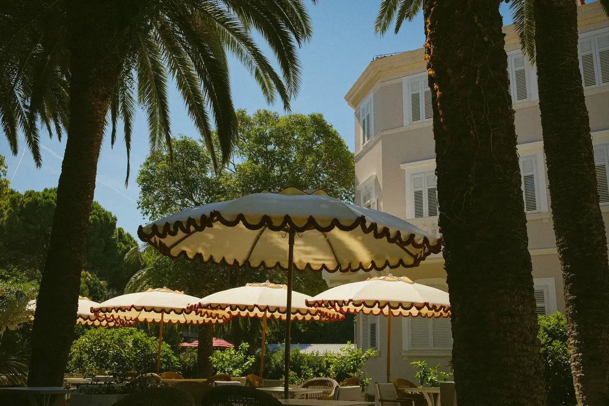Scalloped parasols beneath the palms in front of the hotel